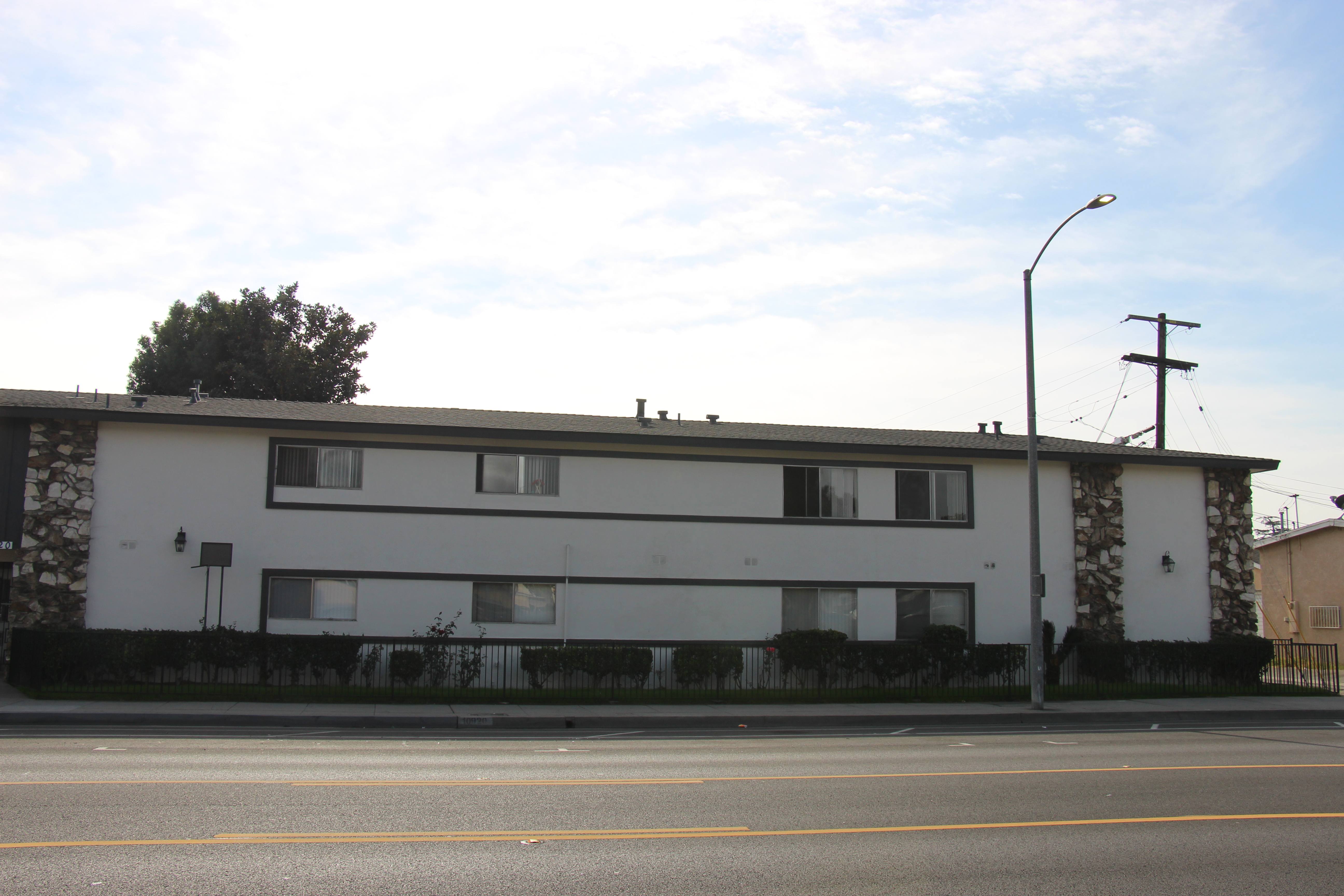 A white building with a black fence in front of it.
